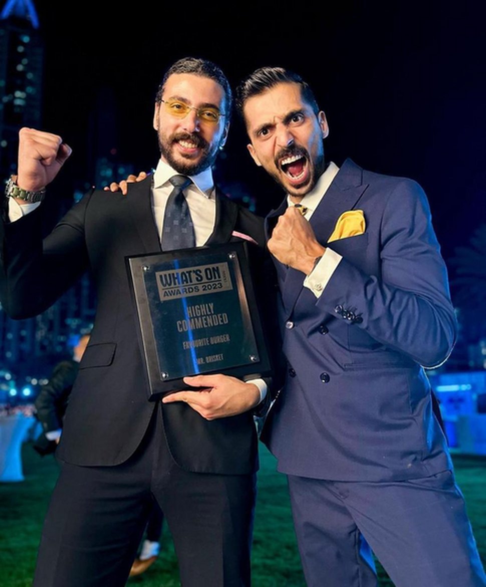 The two founders celebrating with a What's On Awards 2023 plaque